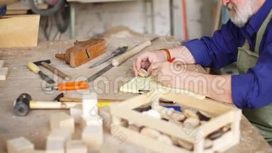 工匠坐在木桌上，用各种乐器进行手工制作。